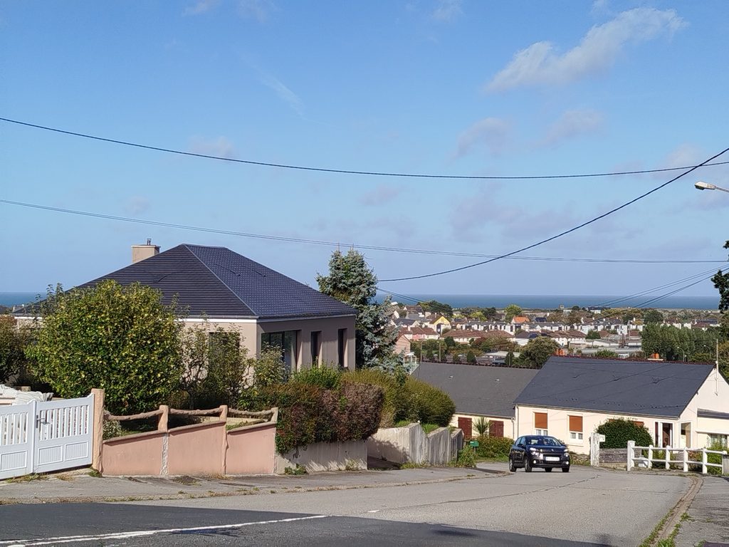 Vue réelle de Querqueville, montrant son environnement résidentiel et la proximité du littoral.